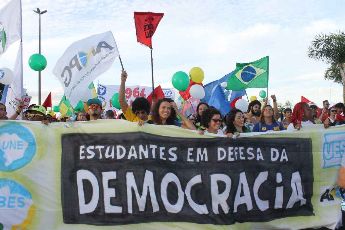 Passeata com faixa escrito Em Defesa da democracia